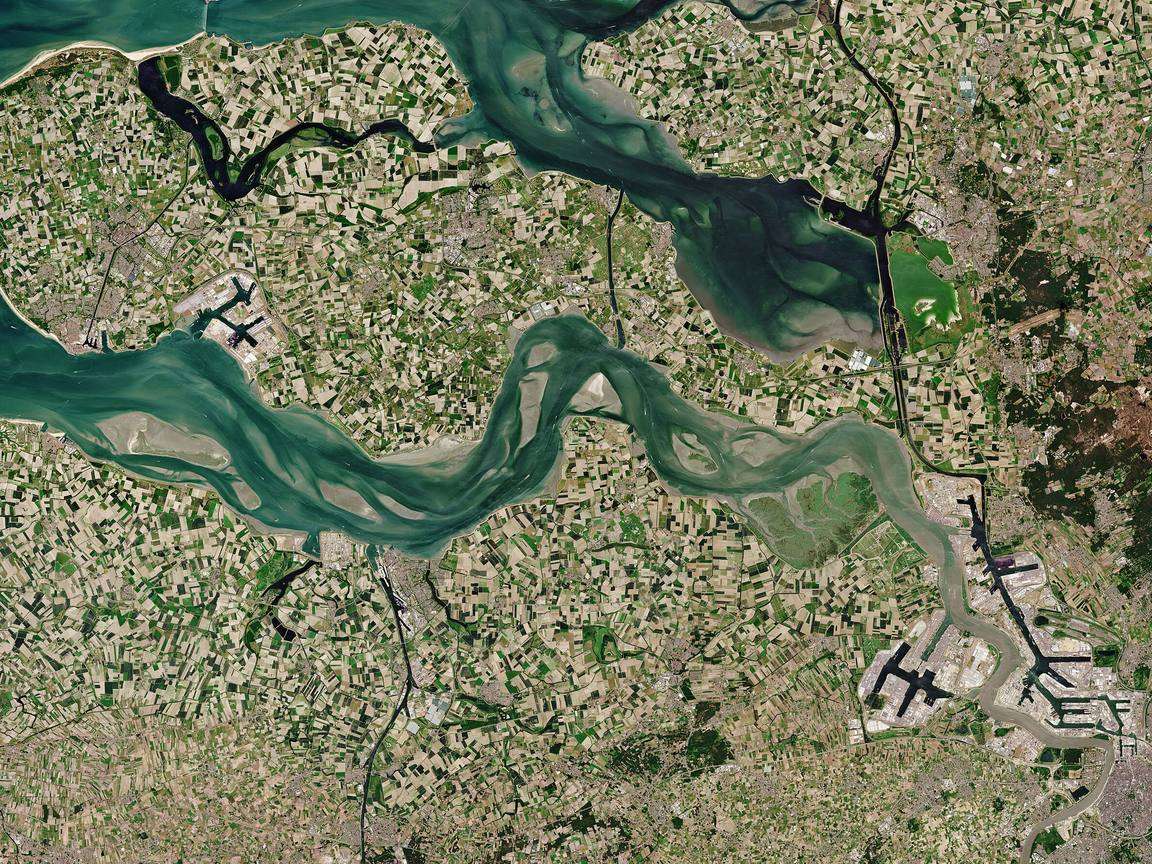Copernicus Sentinel-2 satellite view of farmland in Zeeland, the Netherlands — individual field parcels visible as a patchwork either side of a tidal estuary.